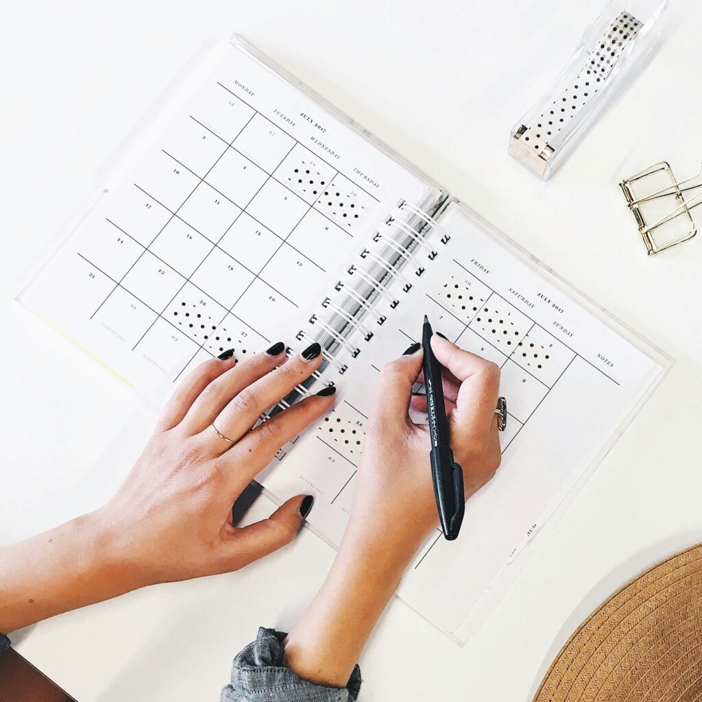 images of two female hands writing something in a planner
